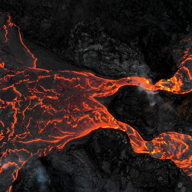glowing red lava flow on black rock