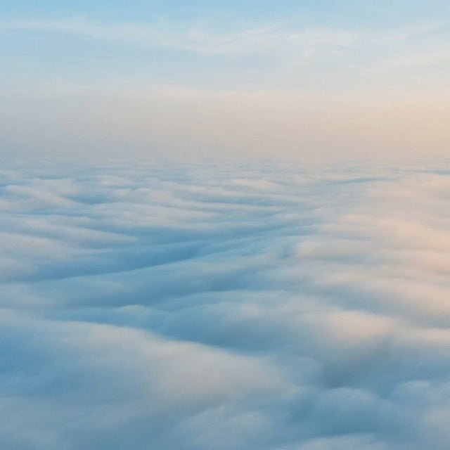 pastel color clouds as seen from airplane window; pink sunset over time lapse water surface